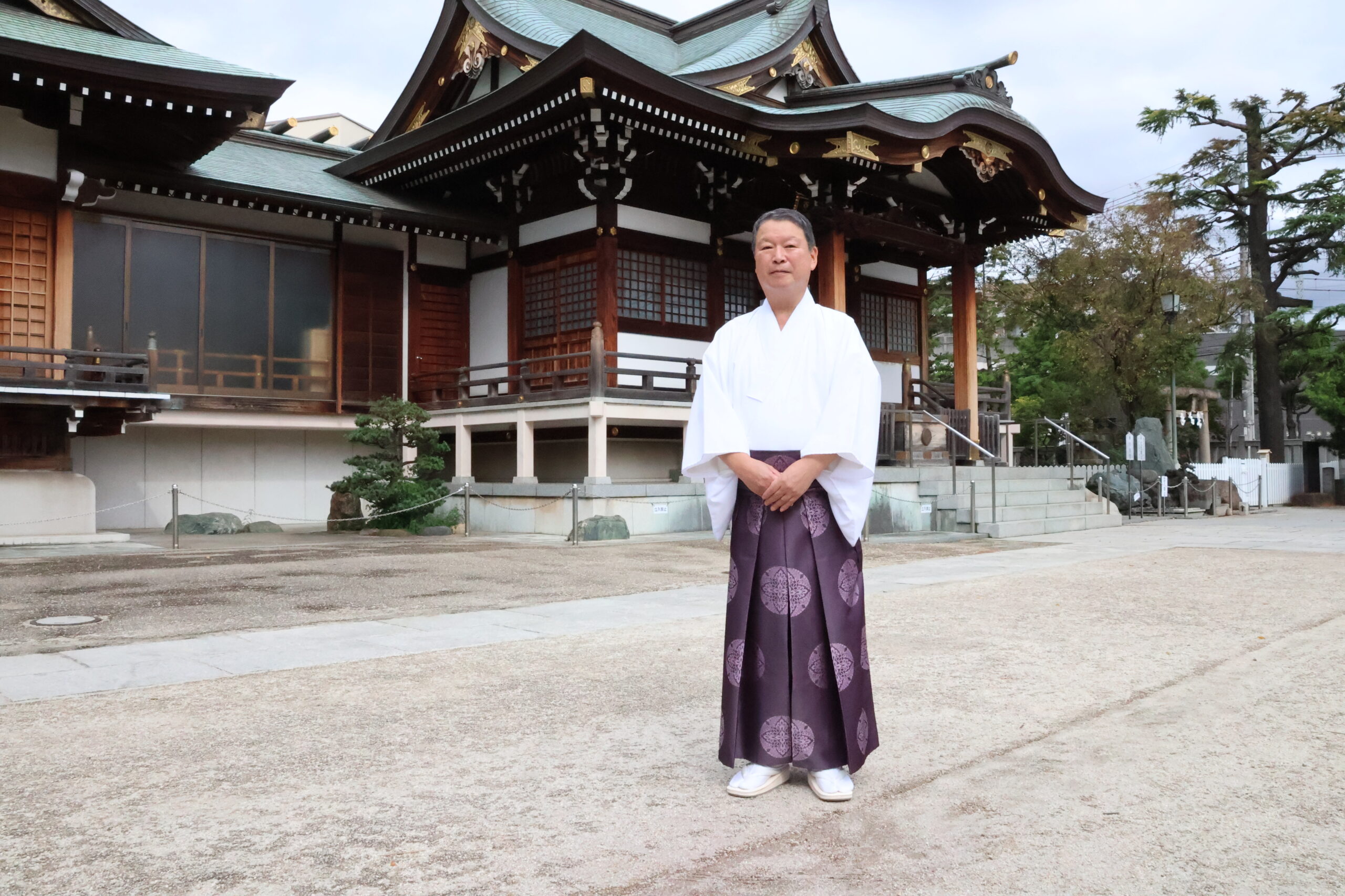 本殿の前で威儀を正す唐松宮司。地域からの信頼も厚い。