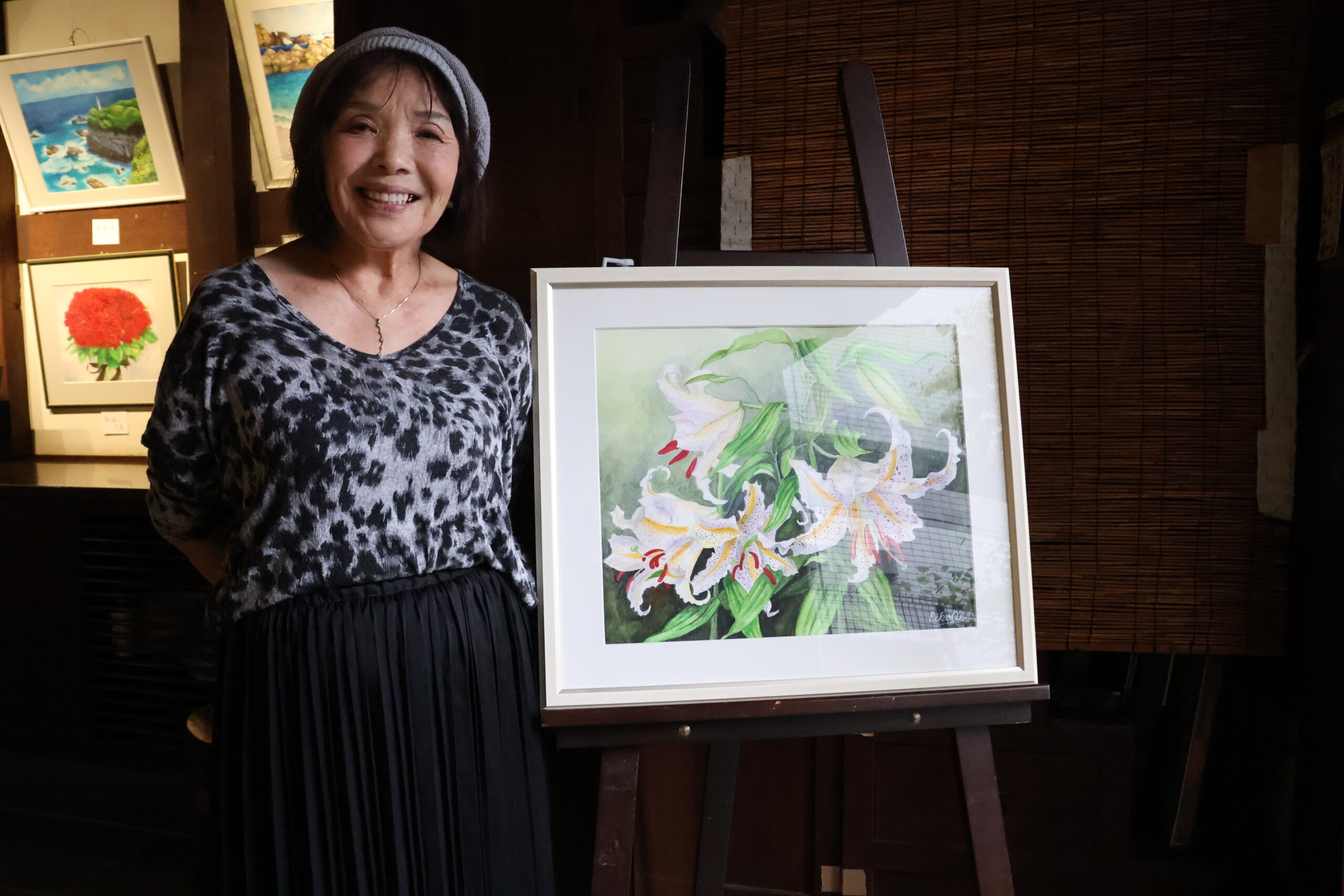 作品の前でほほ笑む阿部榮子さん